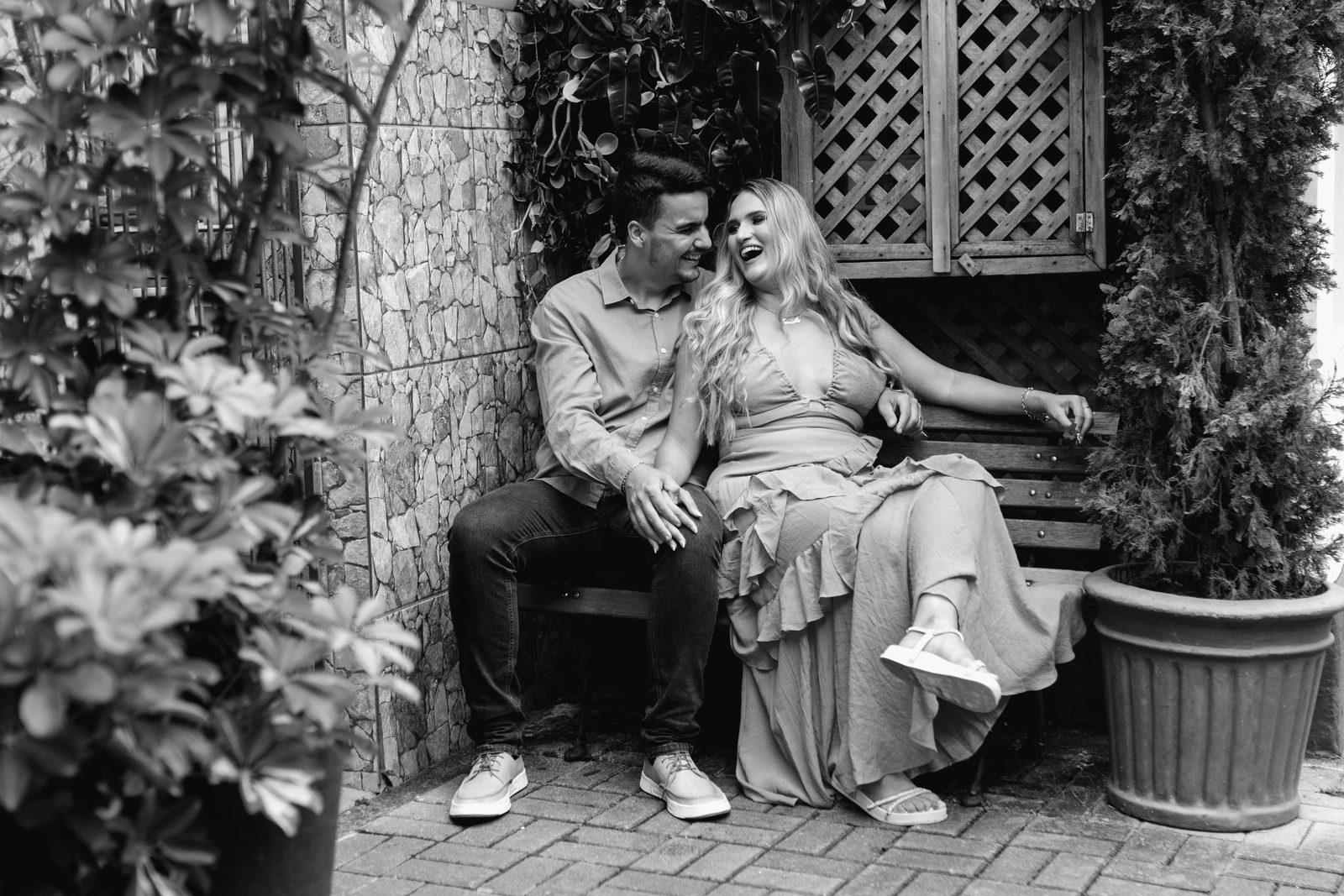 Nadia en Pieter lag op 'n tuinbankie